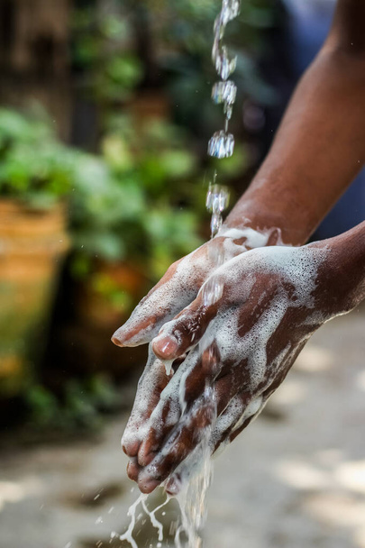 Washing hands.Man washing his hands in the garden at home.Coronavirus pandemic prevention wash hands with soap warm water and , rubbing nails and fingers washing frequently. Hygiene & Cleaning Hands. - Foto, Imagem