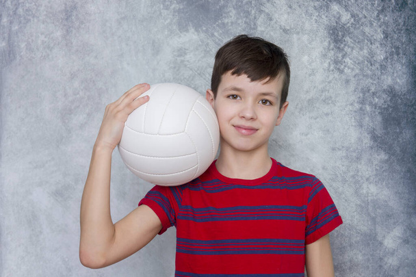 Komean teinipojan muotokuva lentopallon kanssa. Harjoitus online käsite
. - Valokuva, kuva