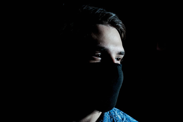 masked guy in the gloom - Фото, изображение