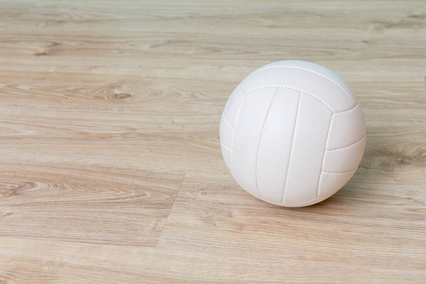 Close Up Of Volleyball Ball On Wooden Floor.  - Фото, изображение