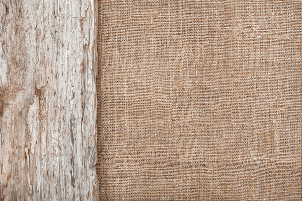 Burlap background bordered by old wood - Foto, afbeelding