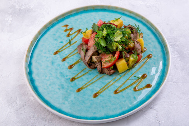 Salad with beef and grilled vegetables. Marble shovel prepared in its own juice, zucchini, fried mushrooms in garlic oil, baked potatoes, fresh tomatoes, herbs, Pesto sauce. European cuisine. - Foto, Bild