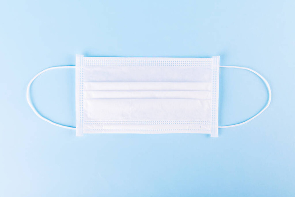Surgical mask with rubber ear straps. Typical 3-ply surgical mask to cover the mouth and nose. Procedure mask from bacteria. Protection concept. - Фото, зображення