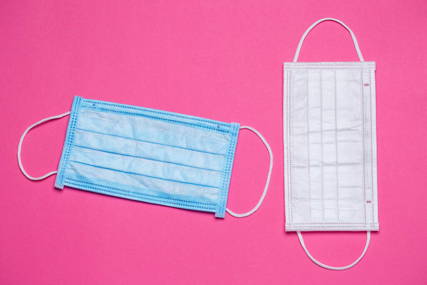 Blue and white medical surgical mask for protection against the virus on a colored background - Φωτογραφία, εικόνα