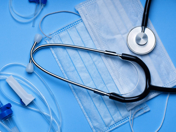 Doktor teşhis koronavirüsü hastalığı için siyah stetoskop, mavi arka planda fotokopi alanı olan sağlık için tıbbi araç. Phonendoskop. Steteskop, maskeler, eldivenler. Tıbbi araçlar.  - Fotoğraf, Görsel