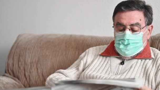oudere man leest krant tijdens coronavirus epidemie quarantaine. - Video