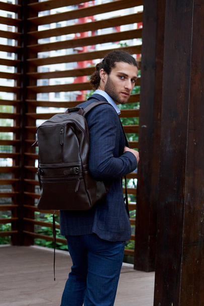 Attractive bearded young man in classic suit with backpack - Foto, imagen