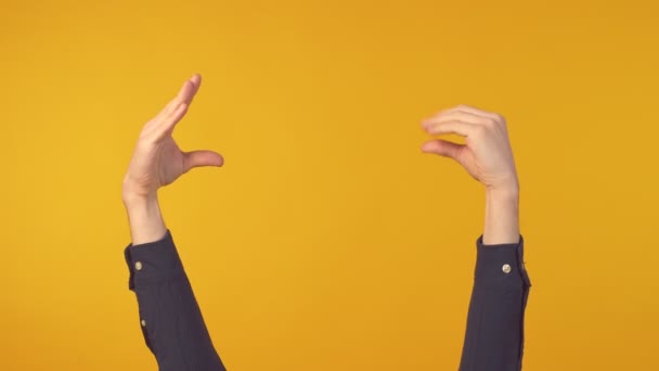 Ręce człowieka pokazując bla bla gest na żółtym tle. Znak dwóch rąk - Materiał filmowy, wideo