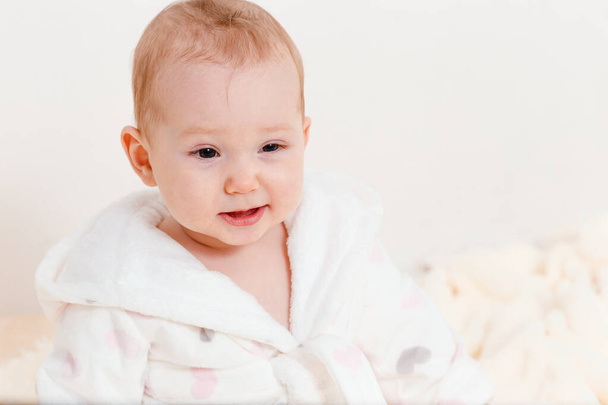 Caucasian baby girl in a white coat close - Foto, Imagen