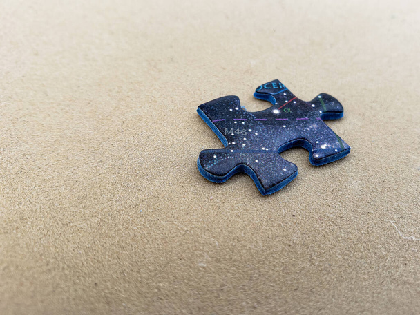 stukjes van een onvolledige puzzelpuzzel op een bruine achtergrond - Foto, afbeelding