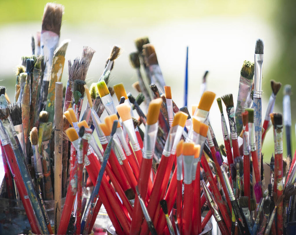 Kovada bir sürü kirli boya fırçası var. Farklı sanatçı fırçaları, yakın çekim görüntüsü - Fotoğraf, Görsel