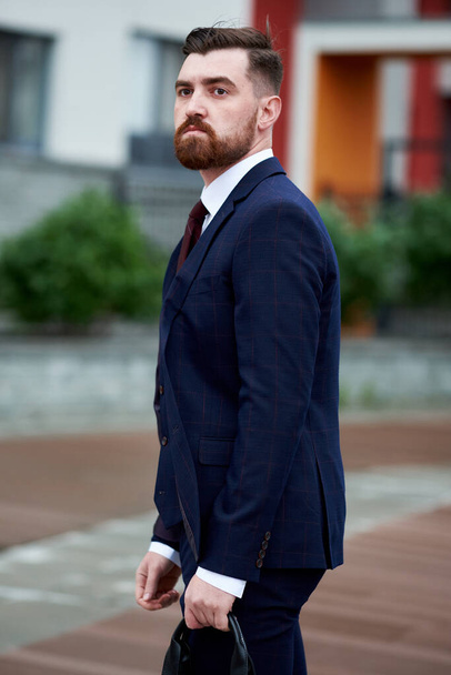 Attractive bearded young man in classic suit with bag. Elegancy and male style - Foto, afbeelding