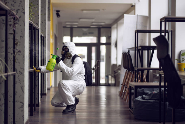 Cleaning and Disinfection at town complex amid the coronavirus epidemic. Professional teams for disinfection efforts. Infection prevention and control of epidemic. Protective suit and mask - Photo, Image