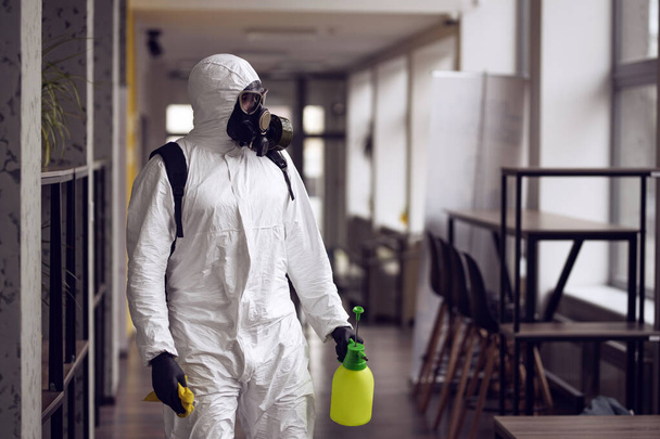 Cleaning and Disinfection at town complex amid the coronavirus epidemic. Professional teams for disinfection efforts. Infection prevention and control of epidemic. Protective suit and mask - Foto, imagen
