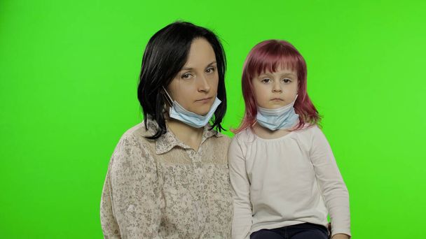 Kranke Mutter und Tochter in medizinischer Maske. Coronavirus-Konzept. Familienquarantäne - Foto, Bild