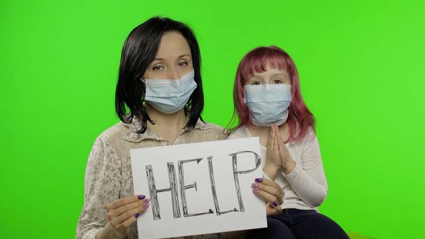 Mère et fille malades montrent la page avec un message d'aide. Concept de coronavirus
 - Photo, image