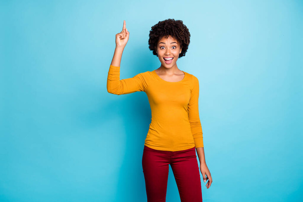 Muotokuva innoissaan fiksu afro amerikkalainen tyttö ajatella ajatuksia ihana ratkaisu nostaa etusormi ylös vaikuttunut huutaa wow omg yllään housut pusero eristetty yli sininen väri tausta
 - Valokuva, kuva