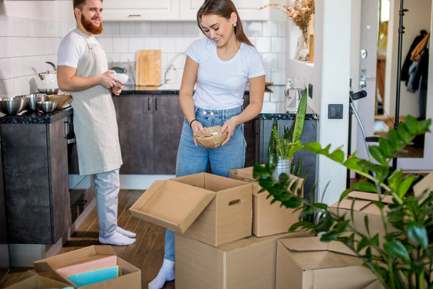 beautiful caucasian married couple unpacking boxes at home - Foto, Imagem