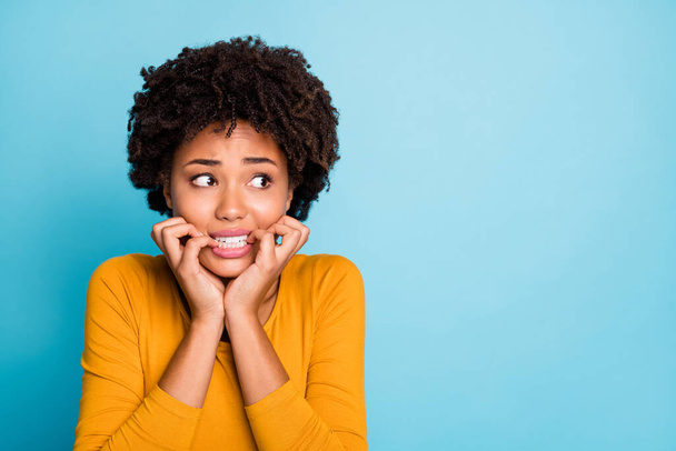 Close up photo of frustrated horrified afro american girl look copyspace fear bite nails teeth wear style stylish trendy pullover isolated over blue color background - Photo, Image