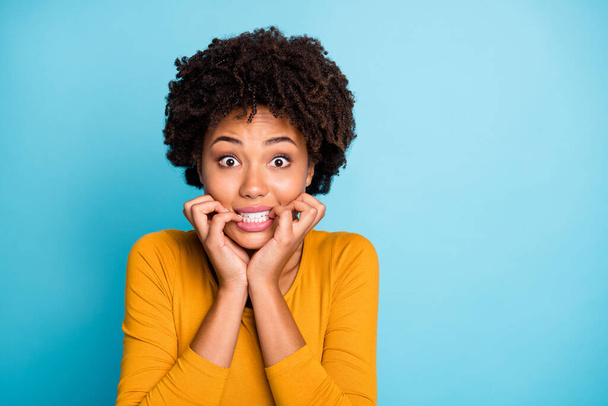 Close up photo of frustrated sad fear afro american girl hear horrible her job mistake news bite nails teeth wear good look sweater isolated over blue color background - Fotó, kép