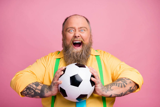 Close-up portrait of his he nice addicted crazy overjoyed cheerful cheery bearded guy holding in hands ball playing having fun isolated over pink pastel color background - 写真・画像