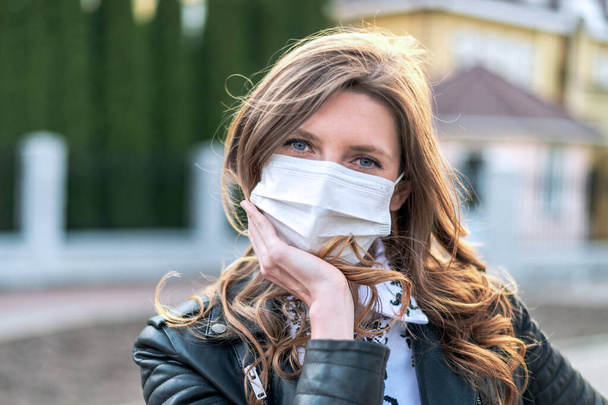 ウィルスマスクだ。GOVD-19 。コロナウイルスの予防のために顔の保護を身に着けて公共空間を歩く女性.  - 写真・画像