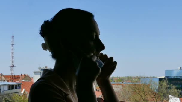 Silhouette of a young woman in quarantine, with a face mask, in the fight against the Coronavirus ( COVID -19), 4K Video Clip - Footage, Video