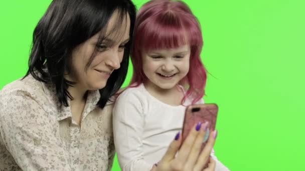 Mère, fille tenant, utilisant un téléphone intelligent parlant sur appel vidéo. Médias sociaux
 - Séquence, vidéo
