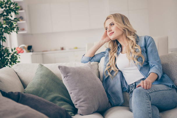 Photo of domestic pretty charming blond lady relaxing sit comfy couch staying home good mood lean head on hand dreamer quarantine time lighted living room indoors - Zdjęcie, obraz