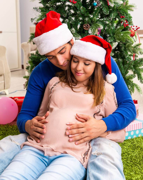 Zwangere vrouw celevrating kerst met man - Foto, afbeelding