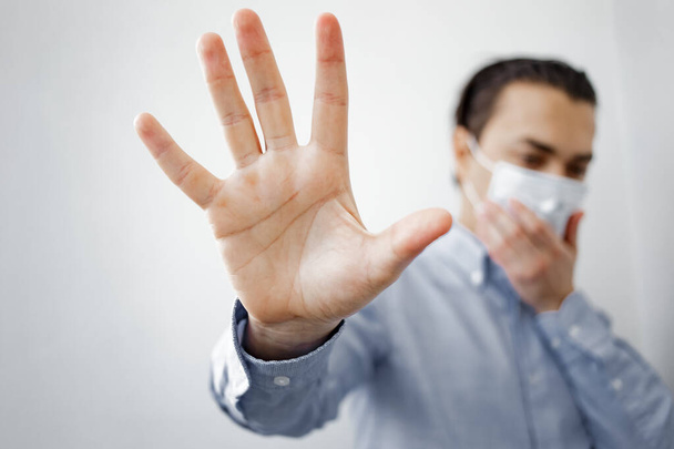 European young man wearing mask and show stop hands gesture for stop corona virus outbreak. Coronavirus and Air pollution pm2.5 concept. Stop coronavirus. Social Distancing. - Foto, Imagem