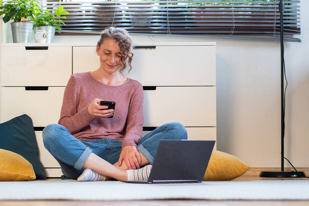 Frau arbeitet oder chattet online von ihrem gemütlichen Wohnzimmer aus - Foto, Bild