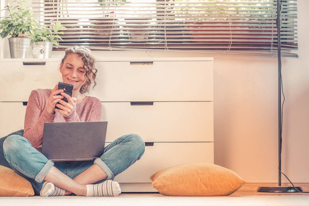 mujer trabajando o charlando en línea desde su acogedora sala de estar
 - Foto, Imagen