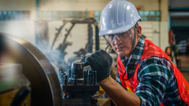 industrial background of caucasian mechanics engineer operating lathe machine for metalwork in metal work factory - Foto, Bild