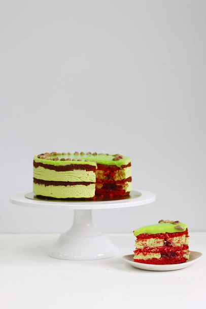 Raspberry cake with pistachio on a light background. red velvet cake. sliced dessert close up - Φωτογραφία, εικόνα