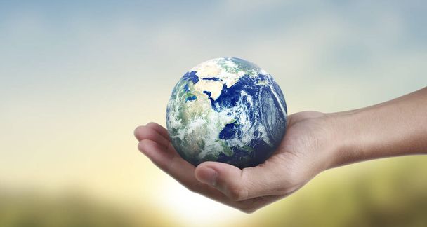 Globus, ziemia w ludzkiej ręce, utrzymujący naszą planetę w blasku. Obraz Ziemi dostarczony przez Nasa - Zdjęcie, obraz