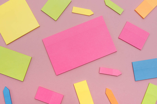 Sticky of different colors on the pink surface. Flat lay. - Fotoğraf, Görsel