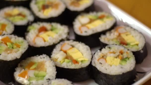 Slow Motion herkullisia makizushi asetettu lohi tarjoillaan valkoisella lautasella. Perinteinen rullattu sushi japanilainen ruoka ravintolassa. Nori roll riisin seeweed ja kalaa gourmet menu.-Dan
 - Materiaali, video