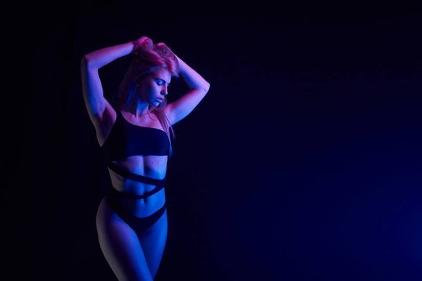 Pole dance girl avec un corps parfait en lingerie sexy noire. Concept de boîte de nuit
 - Photo, image