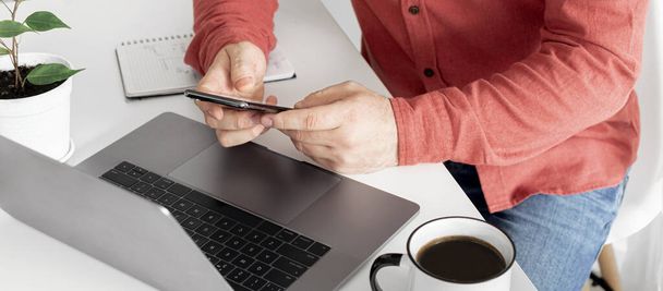 Geschäftsmann arbeitet mit Laptop aus der Ferne oder kommuniziert in sozialen Netzwerken zu Hause - Foto, Bild