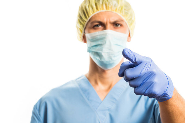 doctor points finger in medical clothes with rubber gloves and a mask , portrait on a white background - Foto, Bild