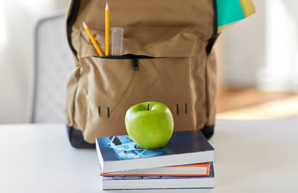 school backpack with books and apple on table - Φωτογραφία, εικόνα