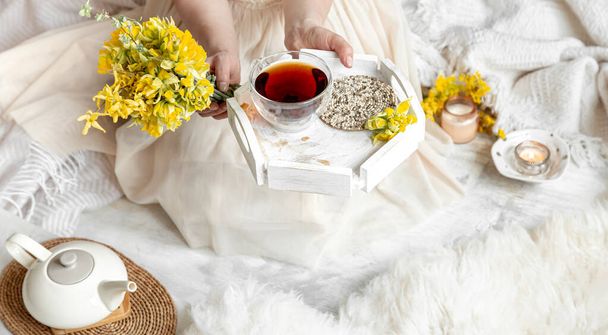 Frühlingsstillleben mit einer Tasse Tee und Blumen. Heller Hintergrund, blühendes und gemütliches Haus. - Foto, Bild