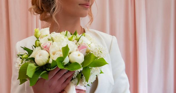 Beautiful wedding bouquet of flowers in hands of the bride - Fotó, kép