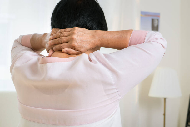 Yaşlı bir kadının boyun ve omuz ağrısı, yaşlı bir kadının sağlık sorunu. - Fotoğraf, Görsel