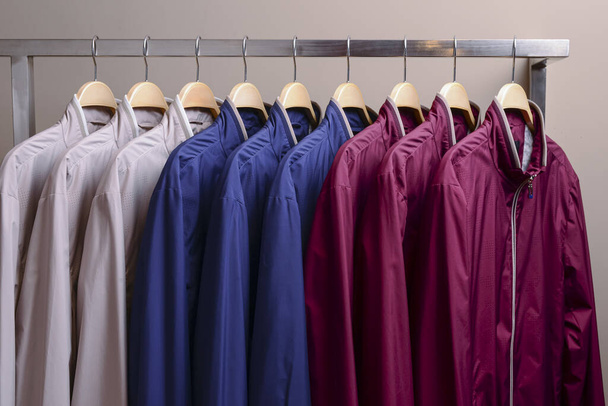 Rivi monia erilaisia värikkäitä huppari takit, urheilu takit miehille ja naisille. Kausittaiset vaatteet varastossa myynnissä
. - Valokuva, kuva