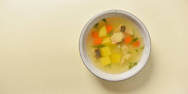 Deliziosa zuppa di stufato con carne e verdure servita in una ciotola bianca su sfondo giallo pastello brillante. Dieta sana
. - Foto, immagini