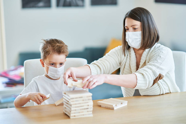 Mother and child playing together at home isolation during coronavirus pandemic - Valokuva, kuva