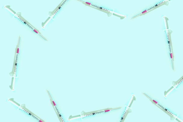 Injekční stříkačky rám na modrém pozadí s kopírovacím prostorem. Vakcína proti koronovému viru. Pandemický a léčebný koncept - Fotografie, Obrázek
