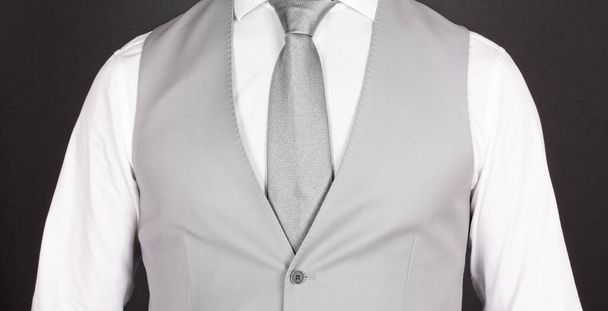 Mies harmaassa puvussa, hopeinen solmio, lähikuva
 - Valokuva, kuva